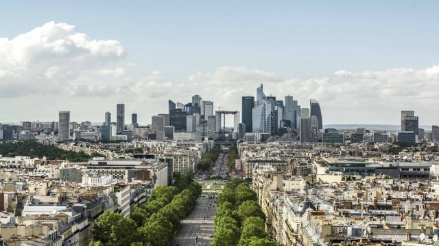 Skyline von Berlin mit einer Allee im Vordergrund und moderner Wolkenkratzer im Hintergrund des Bildes.